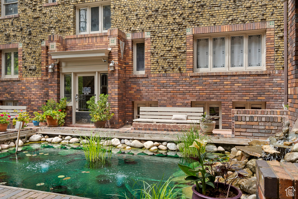 View of patio with a small pond and an outdoor pool