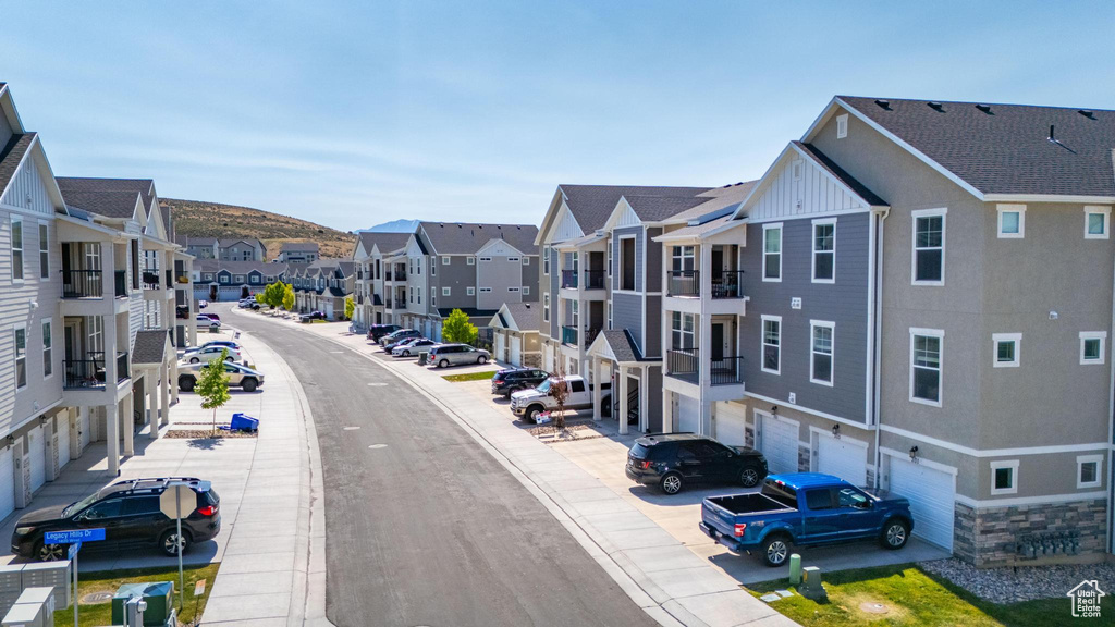 View of asphalt street with a residential view, sidewalks, and curbs