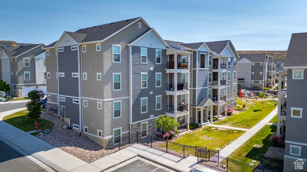 View of building exterior with a residential view and uncovered parking