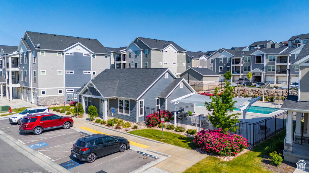 View of property with uncovered parking and a residential view