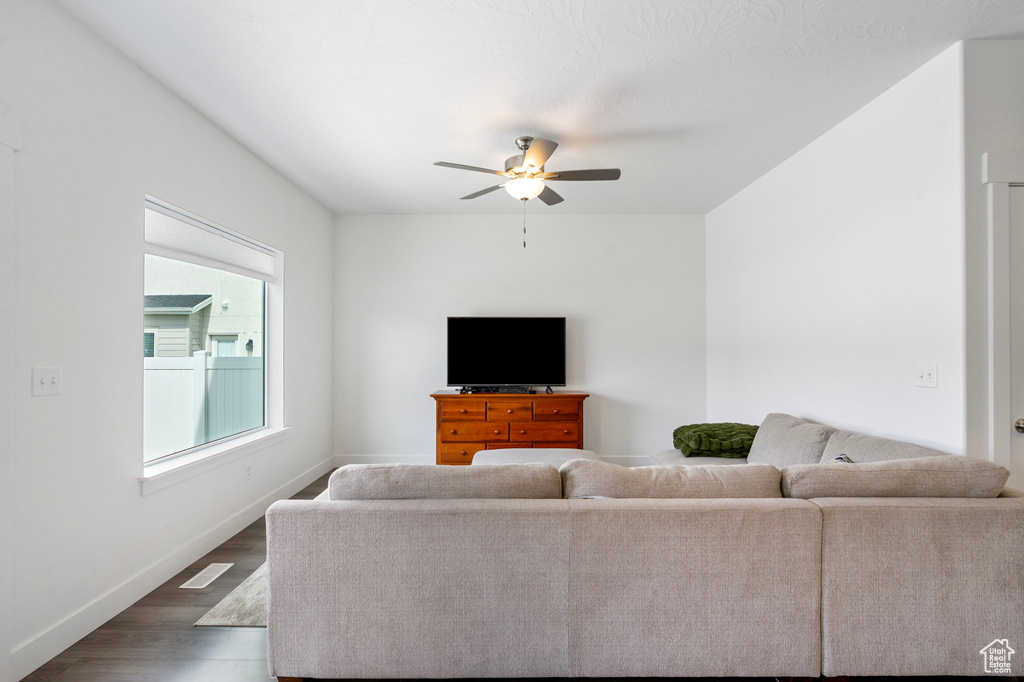 Living area featuring wood finished floors, ceiling fan, and baseboards