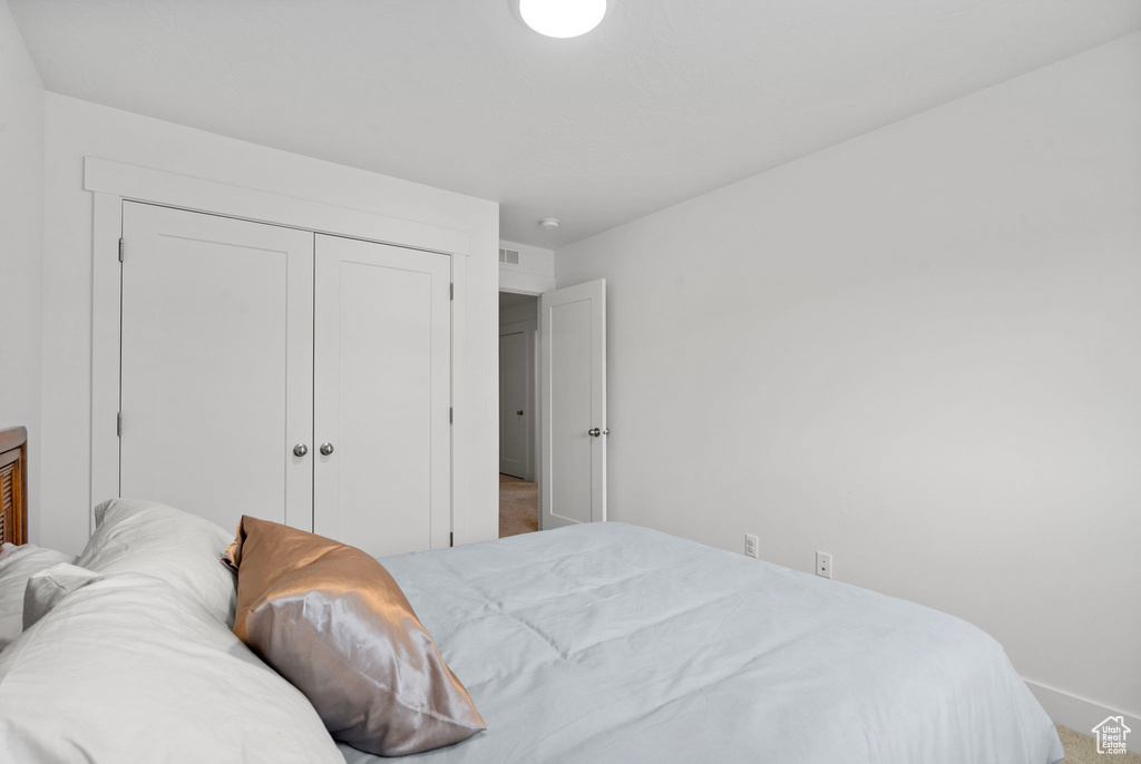 Bedroom with a closet, baseboards, and carpet