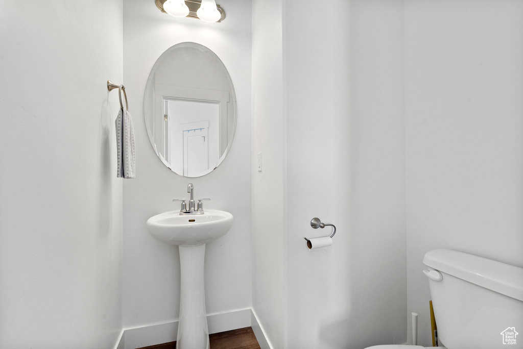 Bathroom with toilet, a sink, and baseboards