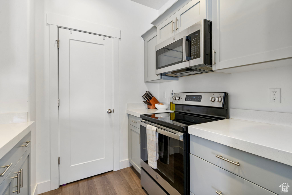 Kitchen featuring stainless steel appliances, gray cabinets, and light countertops
