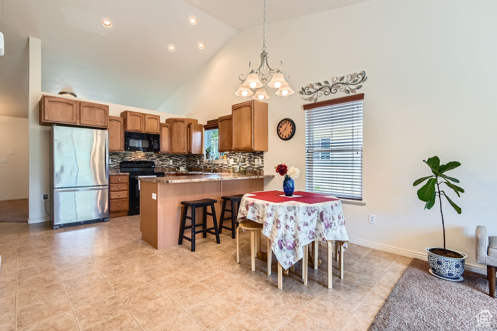 Dining room featuring light tile patterned flooring, a chandelier, high vaulted ceiling, recessed lighting, and baseboards