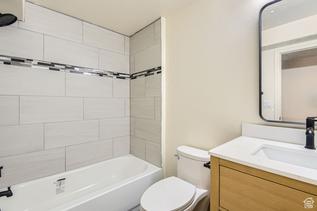 Bathroom with toilet, vanity, and shower / washtub combination