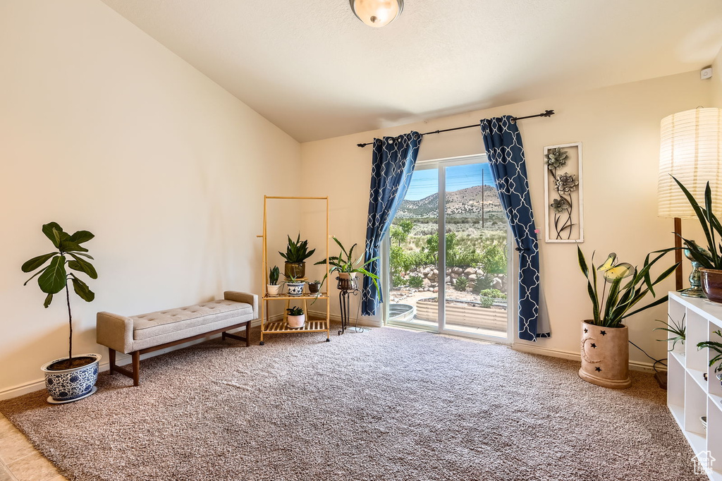 Living area featuring carpet, baseboards, and lofted ceiling