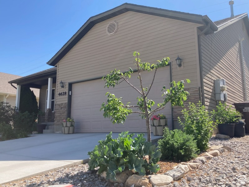 View of side of property with concrete driveway and an attached garage