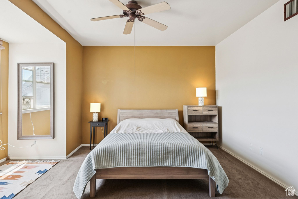 Carpeted bedroom featuring baseboards and a ceiling fan