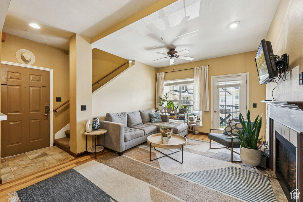 Living area with stairway, a fireplace, ceiling fan, wood finished floors, and recessed lighting