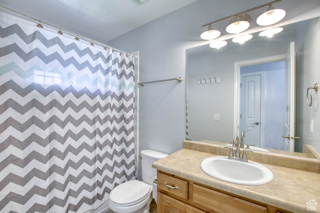 Full bathroom featuring vanity, toilet, and curtained shower