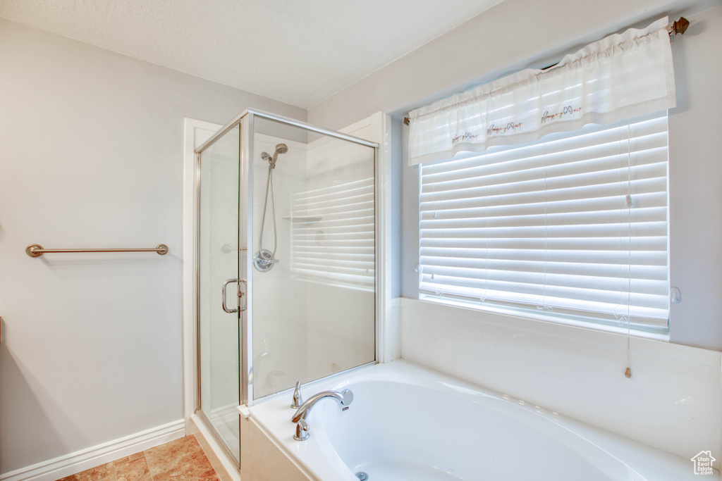 Full bathroom with a garden tub, a stall shower, and tile patterned floors