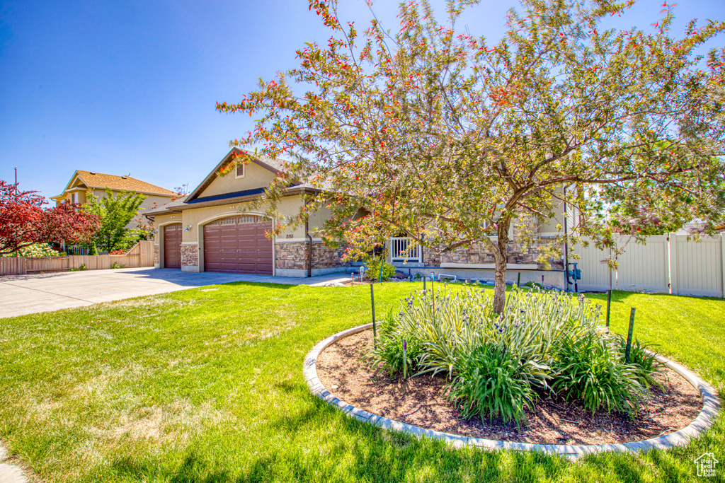 View of front of house featuring concrete driveway, an attached garage, stone siding, and stucco siding