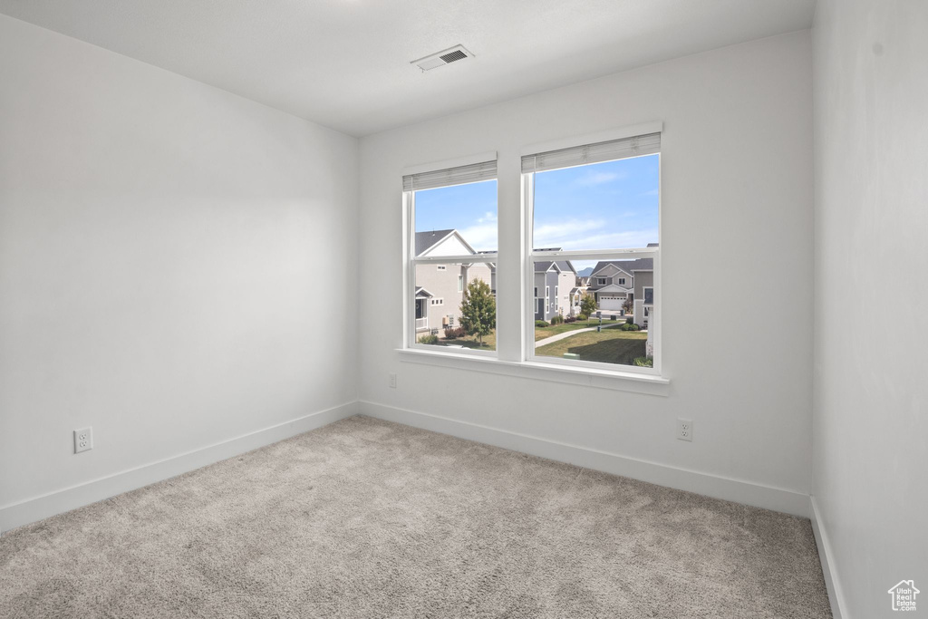 Empty room featuring baseboards and carpet flooring
