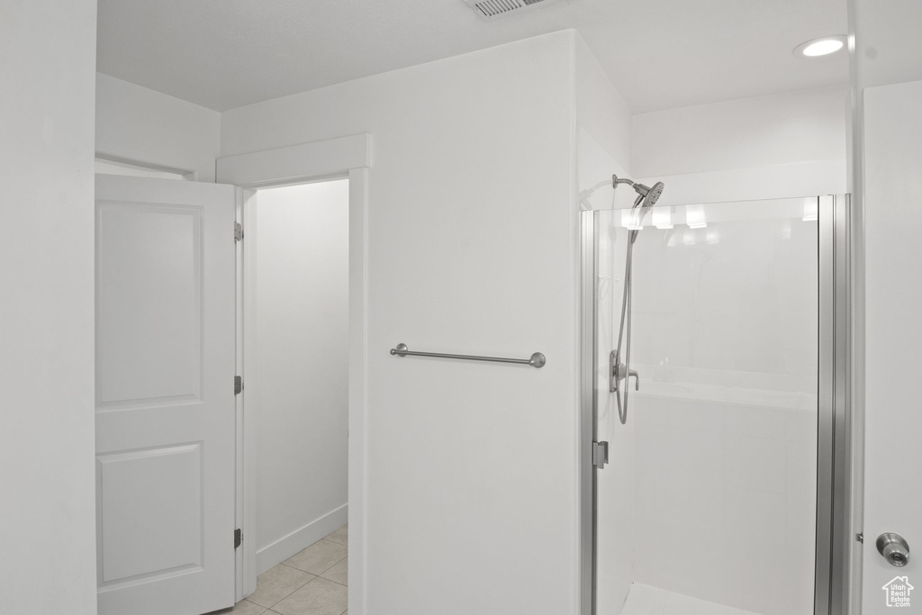 Full bathroom featuring a shower stall and tile patterned flooring
