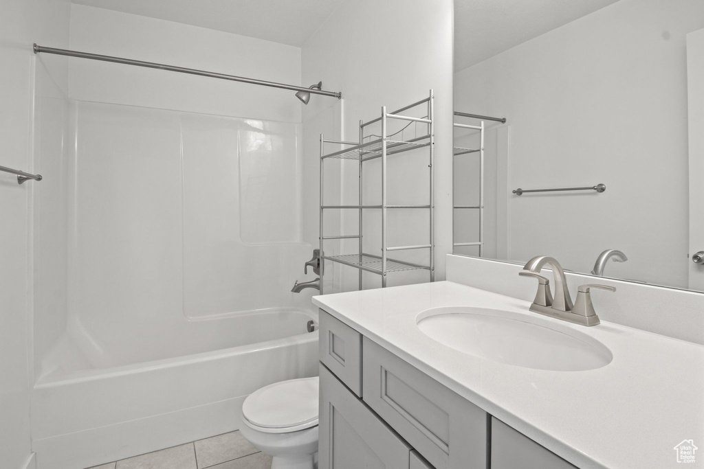 Bathroom featuring toilet, vanity, shower / tub combination, and tile patterned flooring
