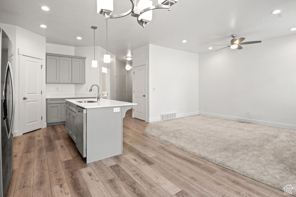 Kitchen featuring gray cabinets, a sink, appliances with stainless steel finishes, light wood finished floors, and ceiling fan