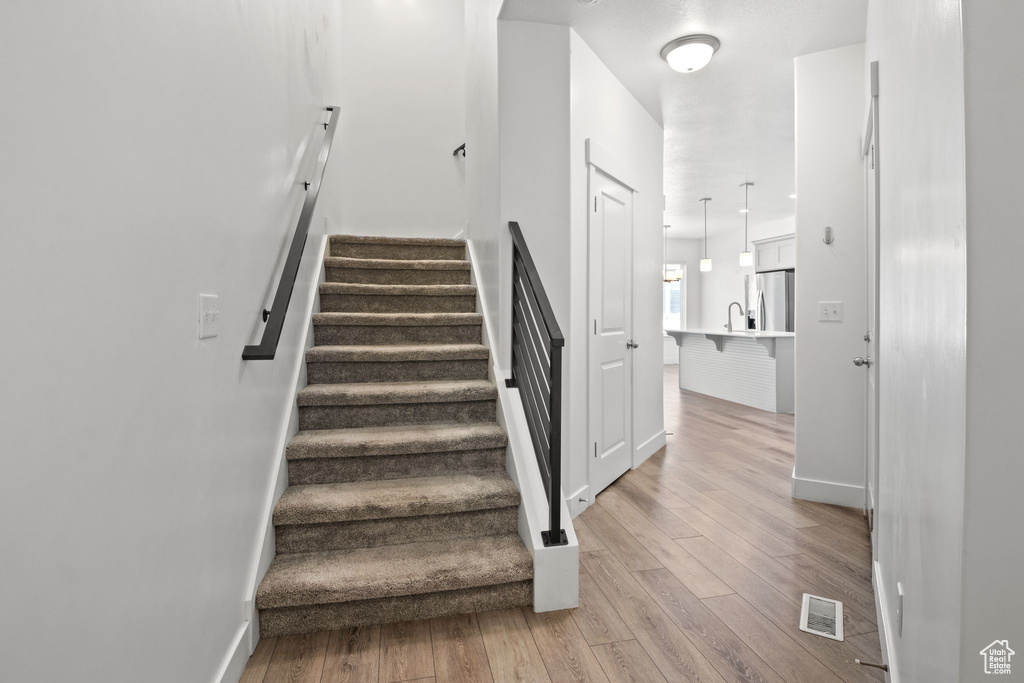 Stairs featuring wood finished floors and baseboards