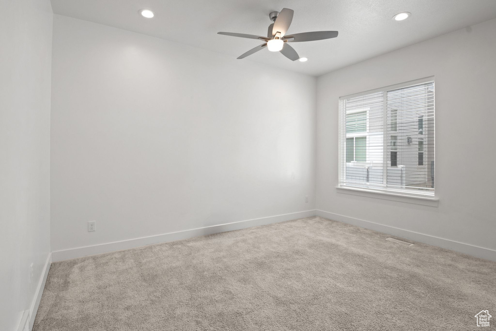 Carpeted spare room featuring ceiling fan, recessed lighting, and baseboards