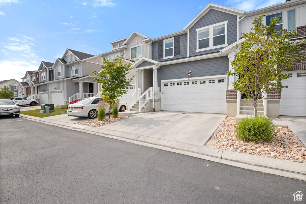 Multi unit property with a residential view, an attached garage, and concrete driveway