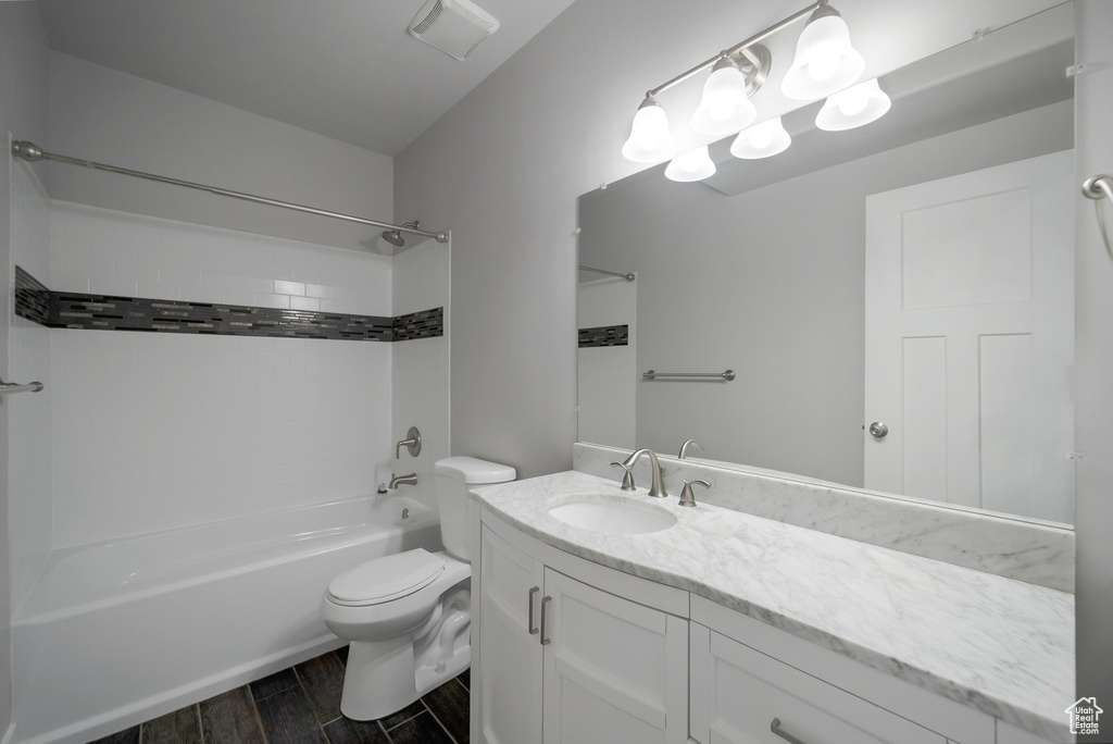 Bathroom featuring shower / bath combination, vanity, toilet, and wood tiled floors