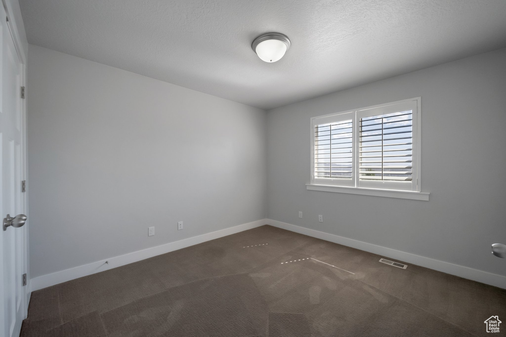 Spare room featuring carpet floors and baseboards