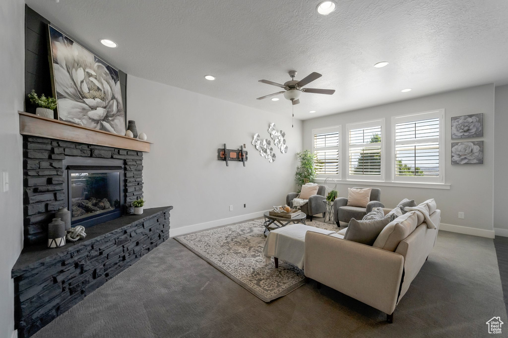 Living area with carpet floors, baseboards, ceiling fan, recessed lighting, and a fireplace