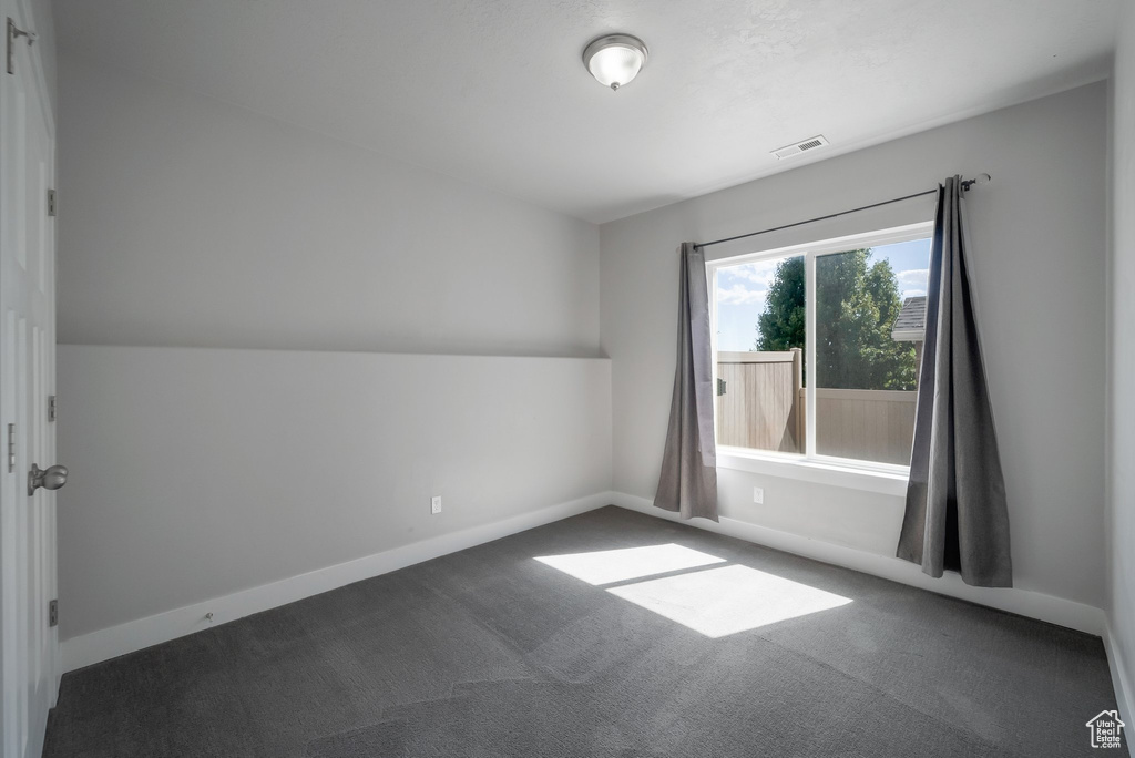 Carpeted empty room featuring baseboards