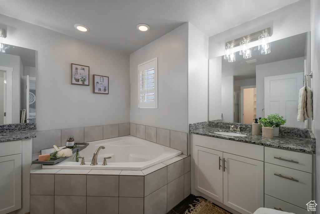 Full bath with vanity, a garden tub, and recessed lighting
