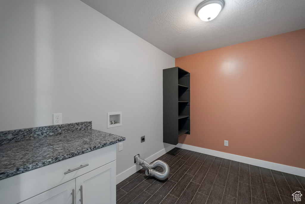 Laundry room with hookup for an electric dryer, hookup for a washing machine, cabinet space, baseboards, and wood tiled floors