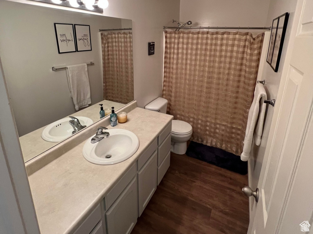 Bathroom featuring wood finished floors, vanity, and toilet