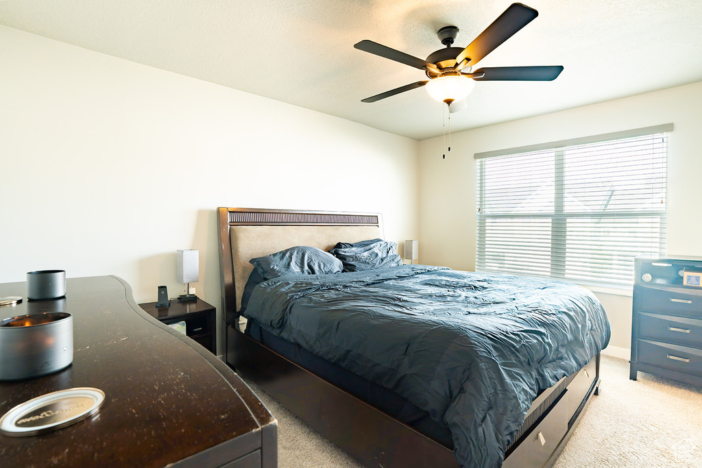 Bedroom featuring light carpet and a ceiling fan