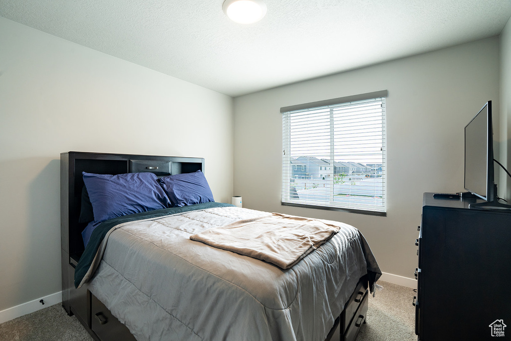 Bedroom featuring light colored carpet and baseboards