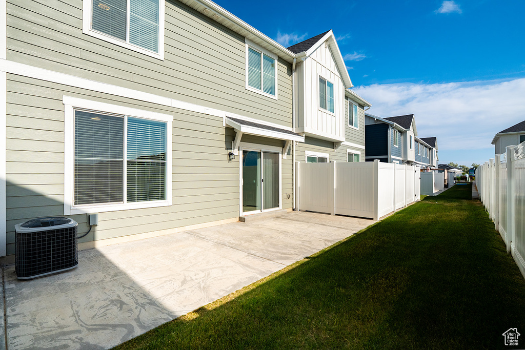 Rear view of property with cooling unit, a patio, a residential view, and board and batten siding