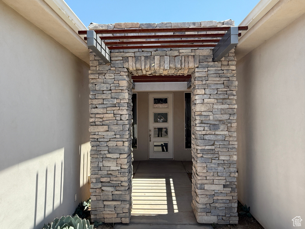 Entrance to property featuring stucco siding and stone siding