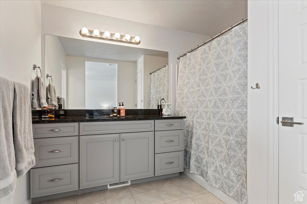 Full bath featuring vanity, tile patterned flooring, and curtained shower