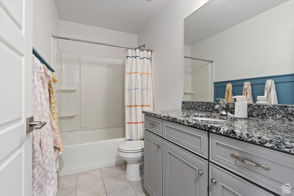Full bath featuring vanity, toilet, shower / bathtub combination with curtain, and tile patterned floors