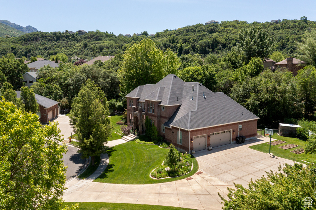 Aerial view of property and surrounding area with a heavily wooded area