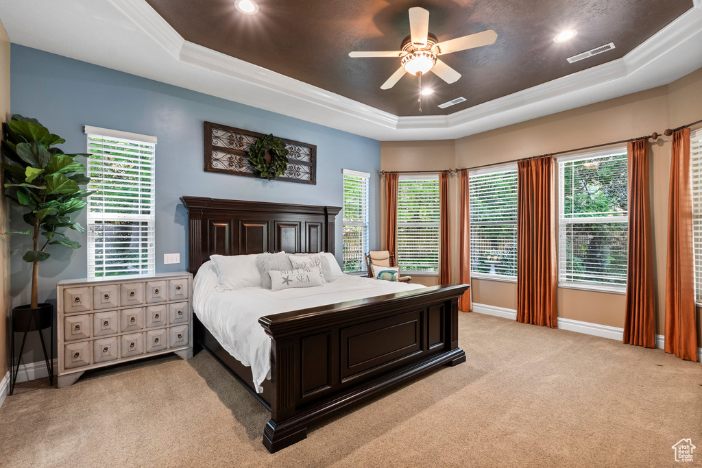 Bedroom featuring a raised ceiling, light colored carpet, baseboards, recessed lighting, and ceiling fan