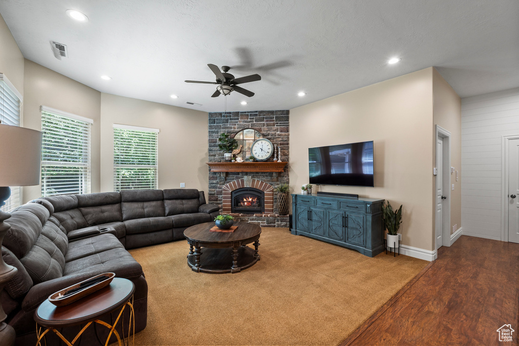 Living room featuring a ceiling fan, recessed lighting, a large fireplace, baseboards, and wood finished floors