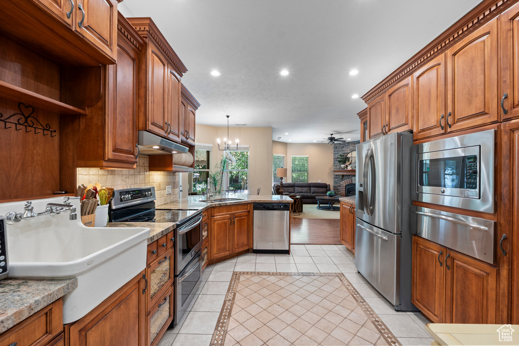 Kitchen with stainless steel appliances, a warming drawer, recessed lighting, a sink, and backsplash