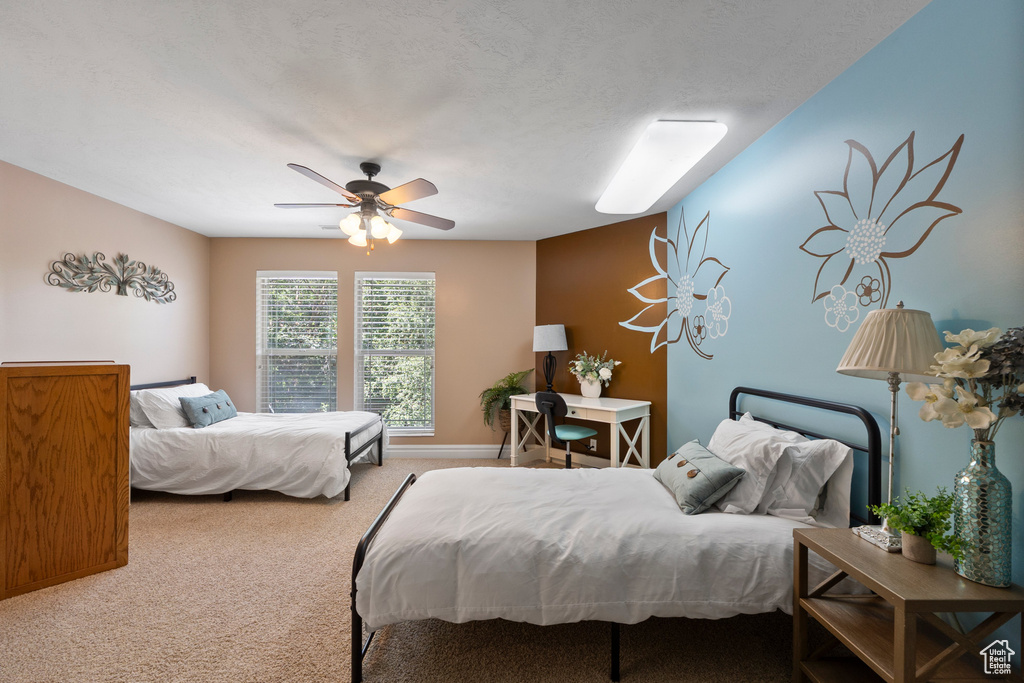 Carpeted bedroom featuring ceiling fan and baseboards