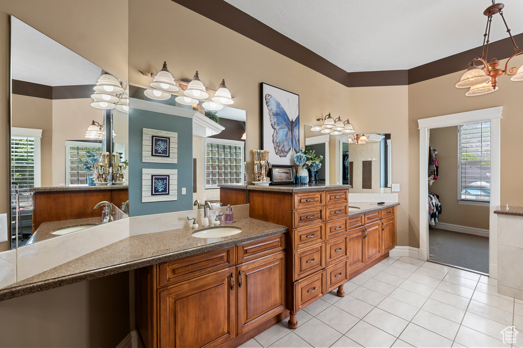 Bathroom featuring two vanities, baseboards, and tile patterned floors
