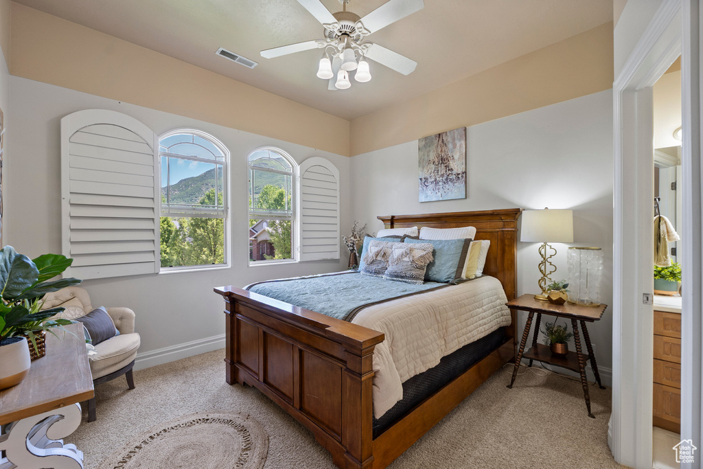 Bedroom featuring light colored carpet, baseboards, and a ceiling fan