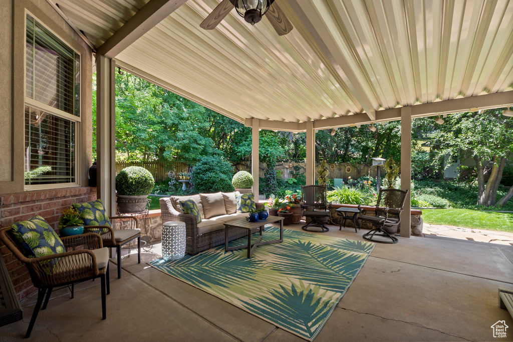 Fenced backyard featuring an outdoor living space, a patio, and ceiling fan