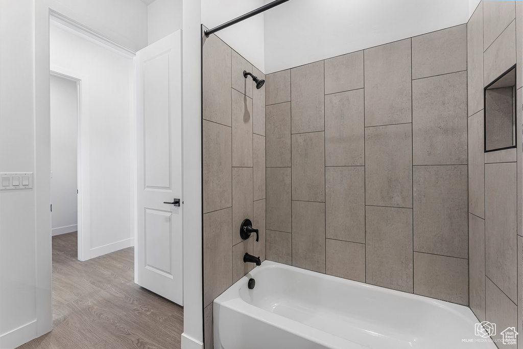 Bathroom with wood finished floors and tub / shower combination