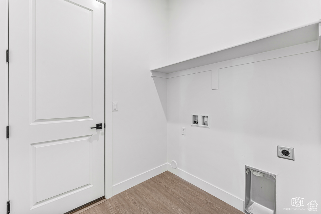 Laundry room featuring washer hookup, hookup for an electric dryer, baseboards, and wood finished floors