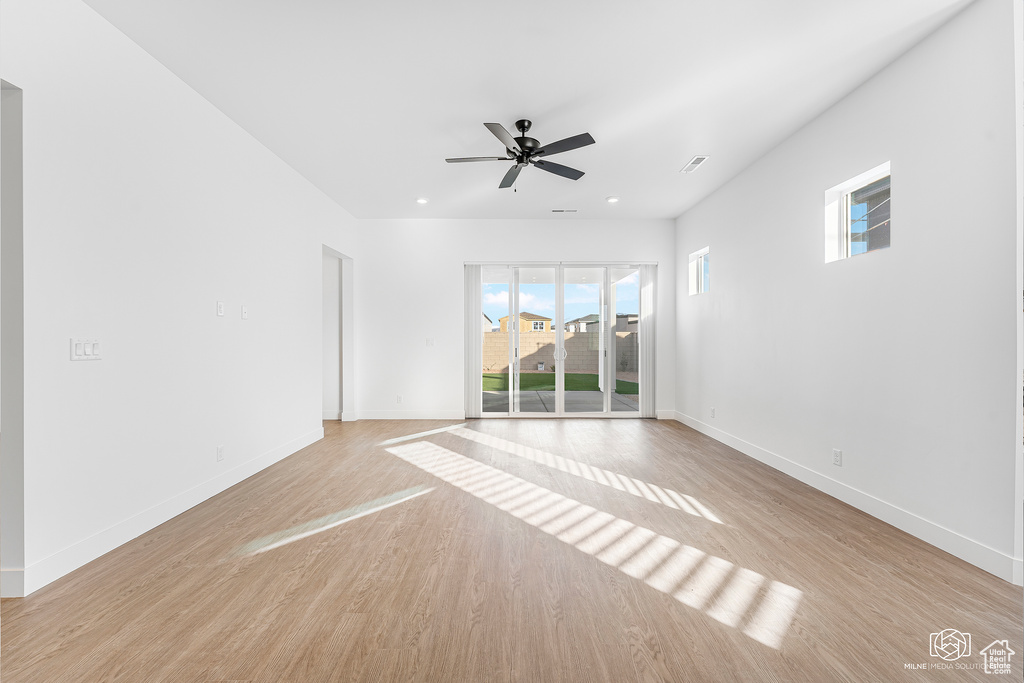 Unfurnished room with baseboards, light wood-style floors, and ceiling fan