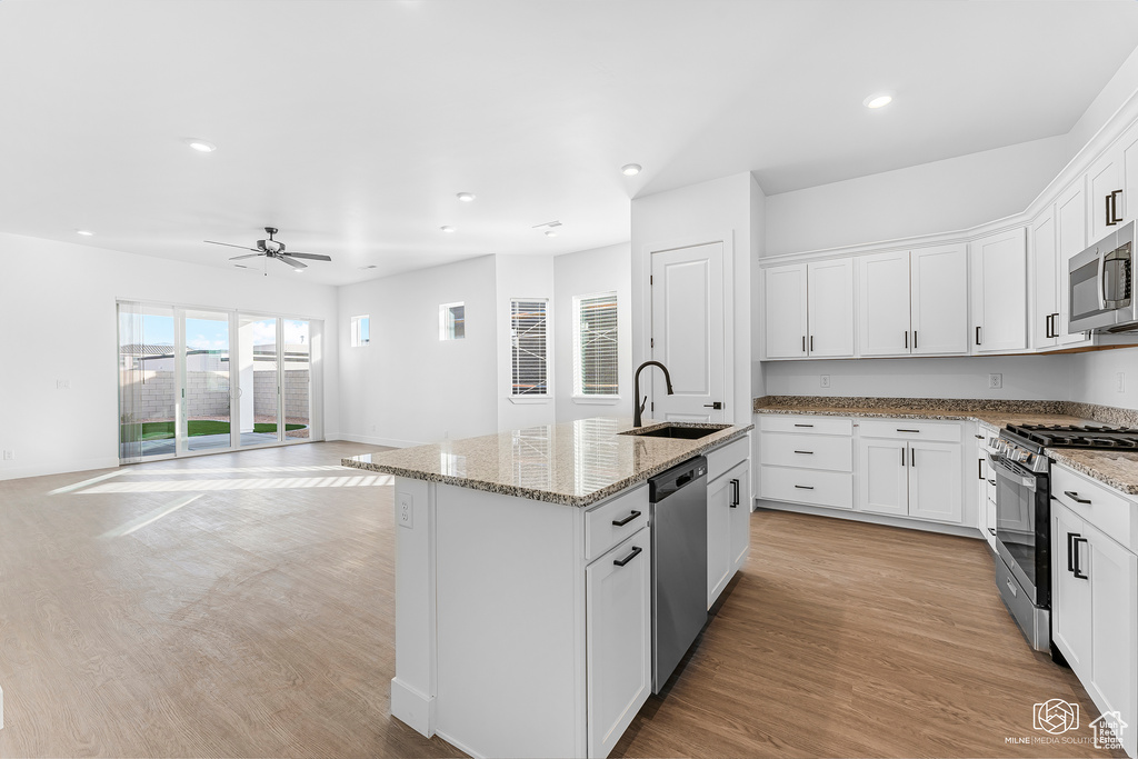Kitchen featuring appliances with stainless steel finishes, a sink, recessed lighting, a center island with sink, and a ceiling fan