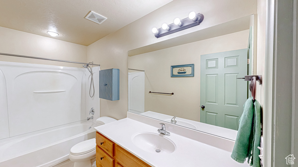 Full bath with toilet, vanity, and shower / washtub combination